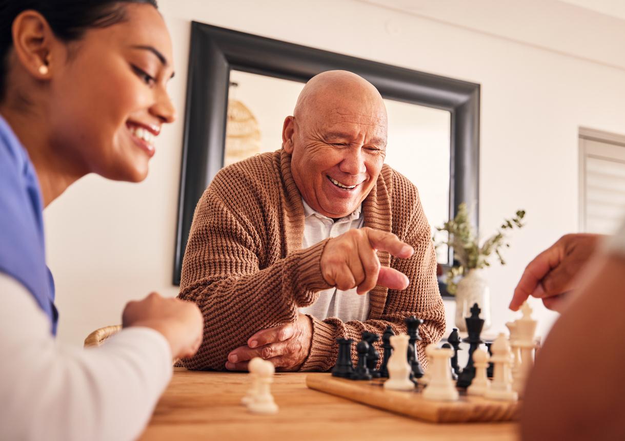 Senior resident and staff member in Assisted Living playing a game together Senior resident and staff member in Assisted Living playing a game together